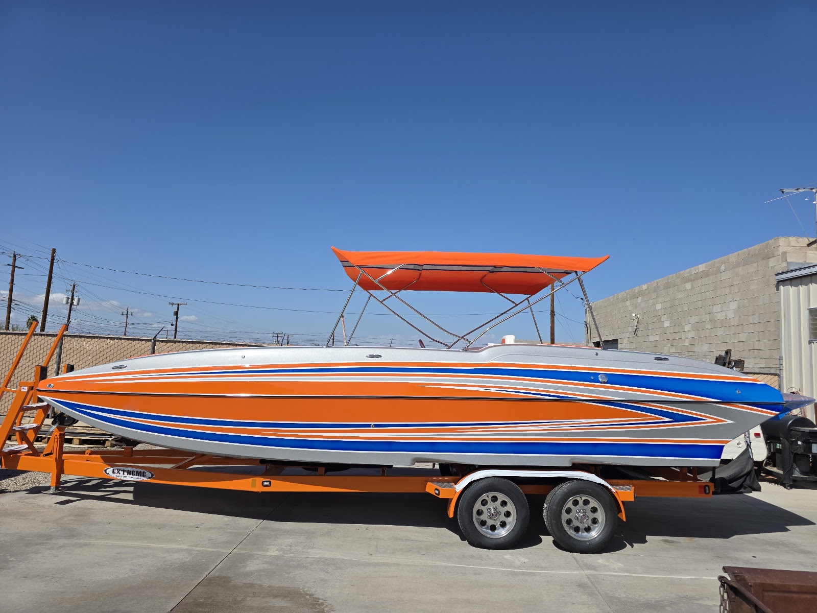 Orange striped performance boat with an orange Sandbar Shade umbrella
