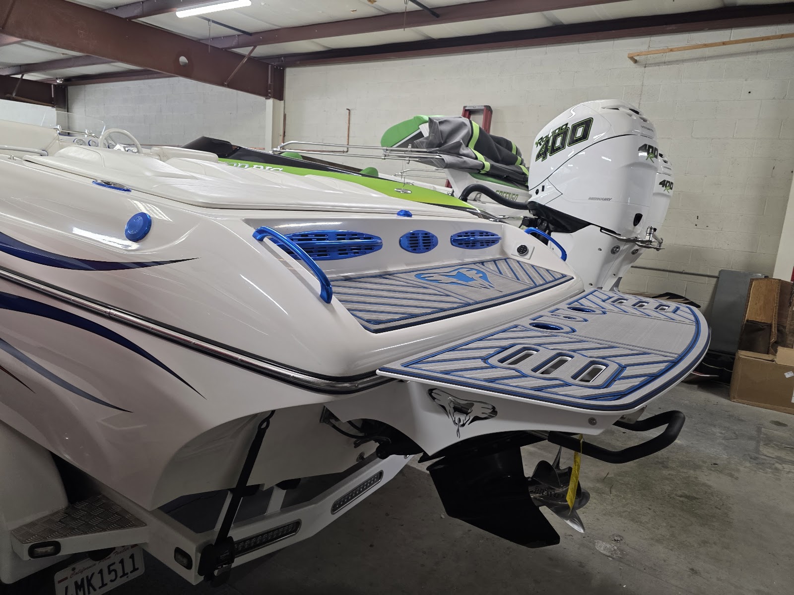 White boat in the shop with fresh blue-accent marine decking