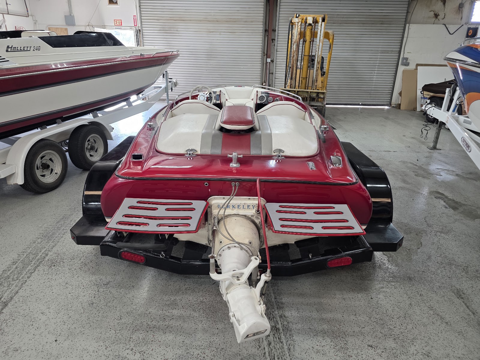 Red performance boat in the shop with a custom rear swim platform