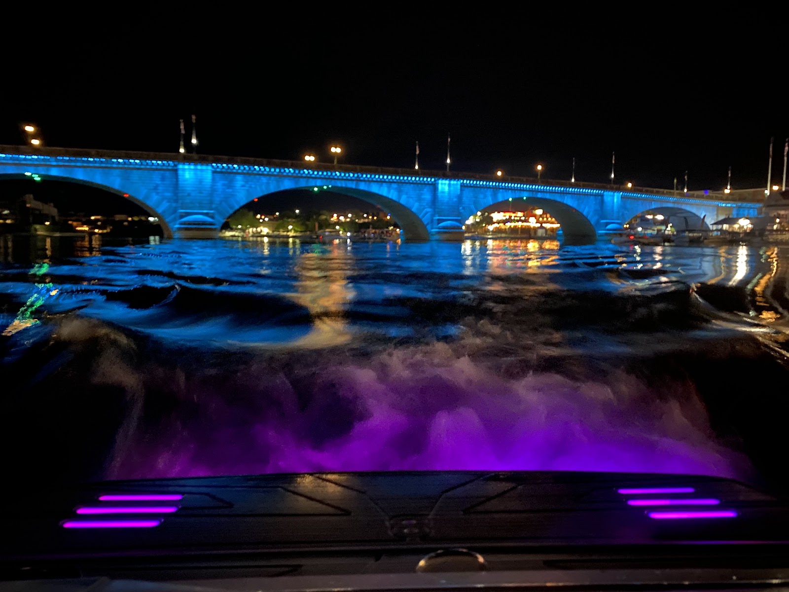 Swim platform glowing with purple underwater lights at night