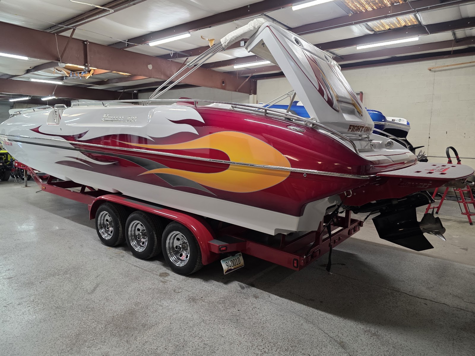 Red flame-painted boat in the shop with a swim platform