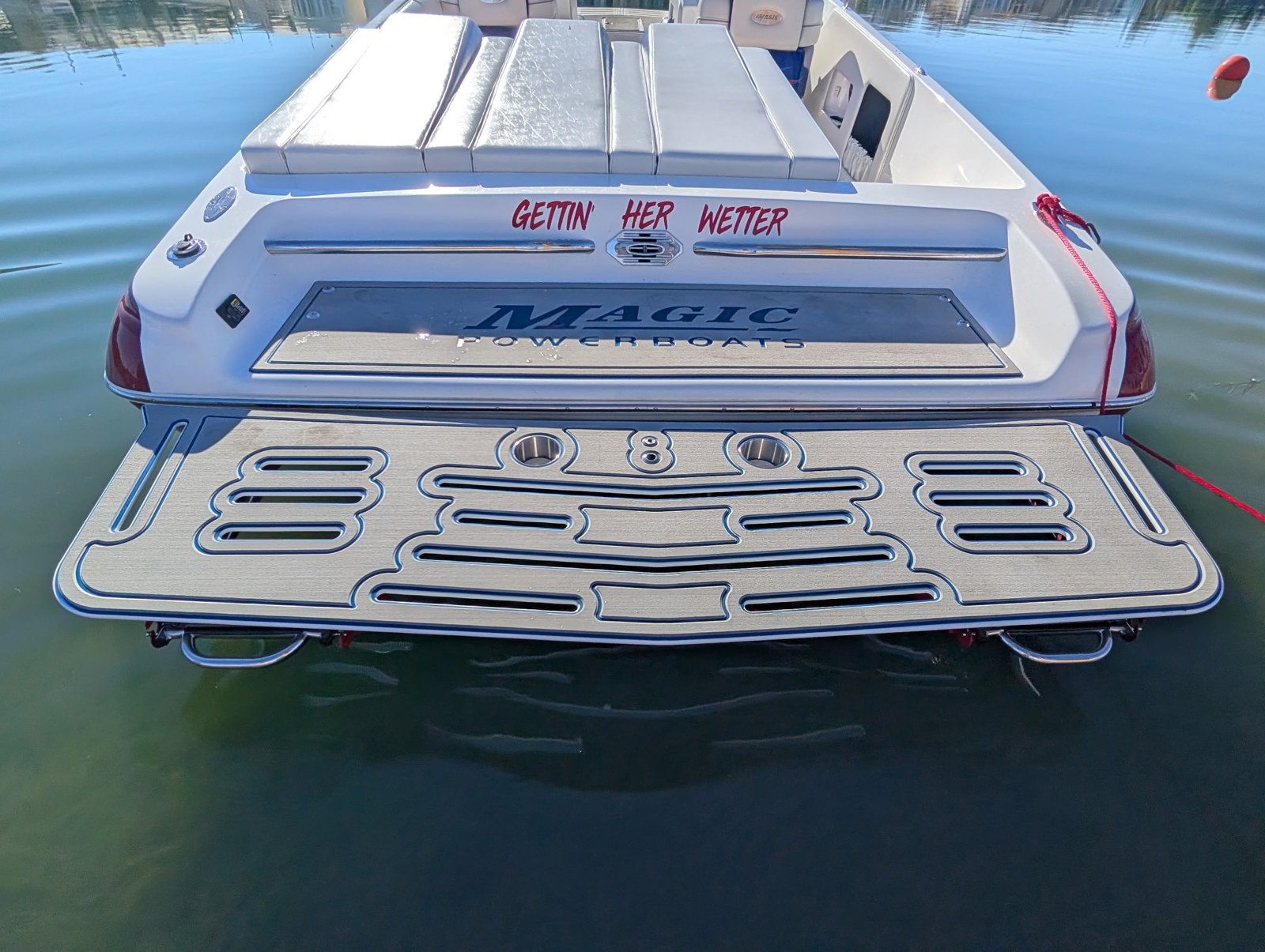 Finished patterned swim platform on a white Magic boat floating on the lake