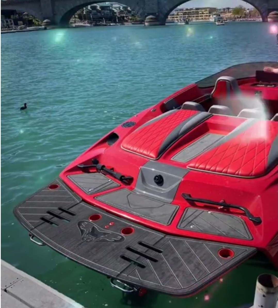 Red personal watercraft with fitted gray marine decking at the dock