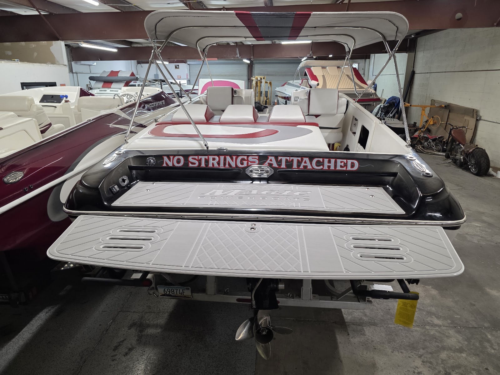 White boat in the shop with a wide gray swim platform
