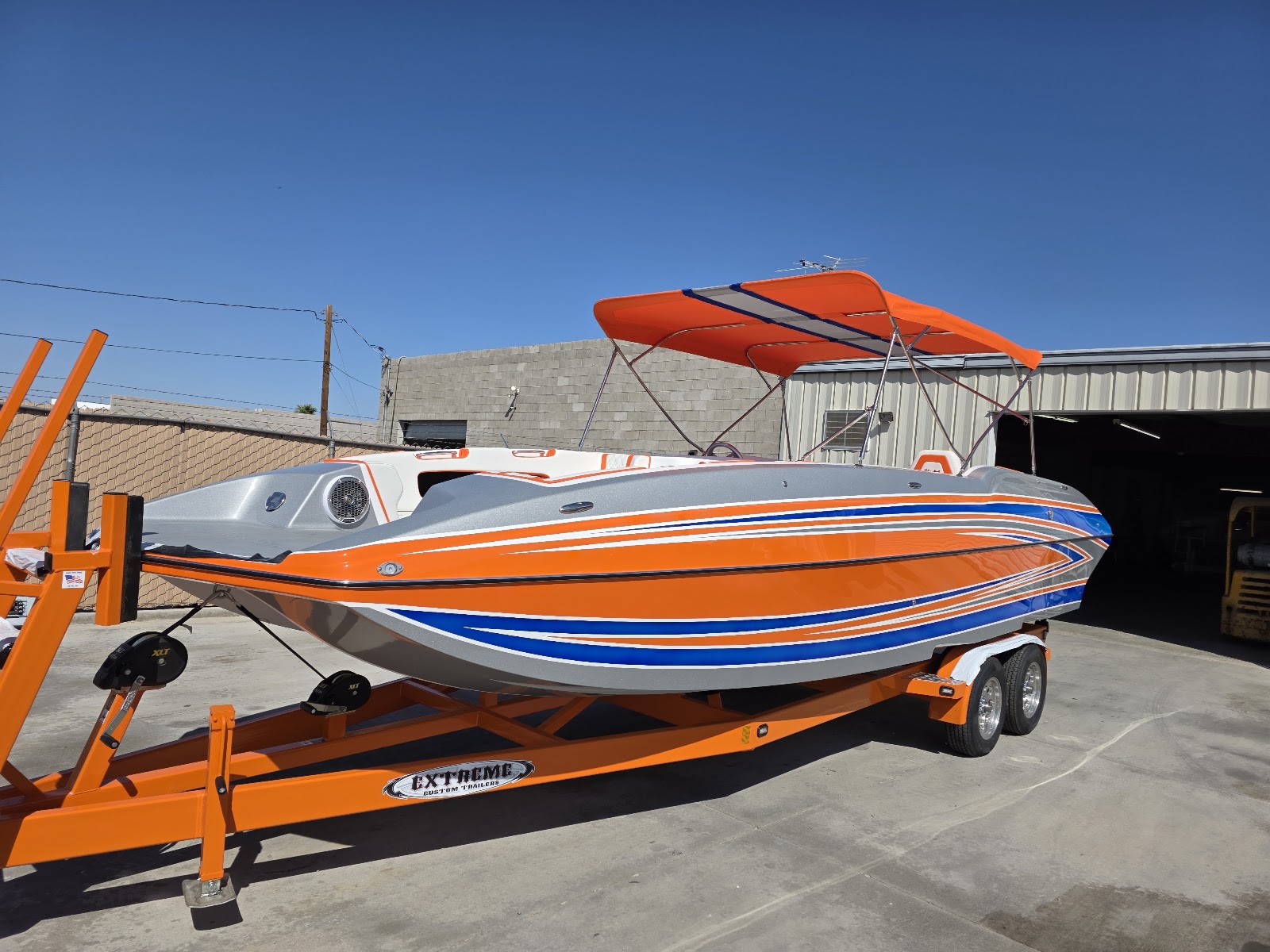 Orange performance boat on a lift shaded by an orange umbrella