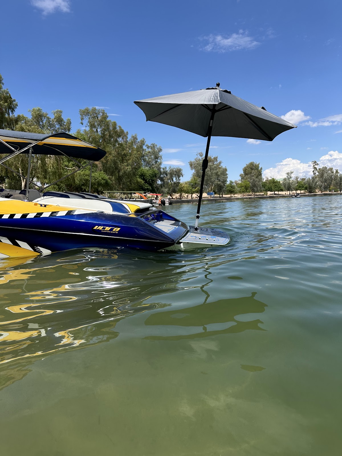 Jet boat with a black Sandbar Shade umbrella floating on the lake