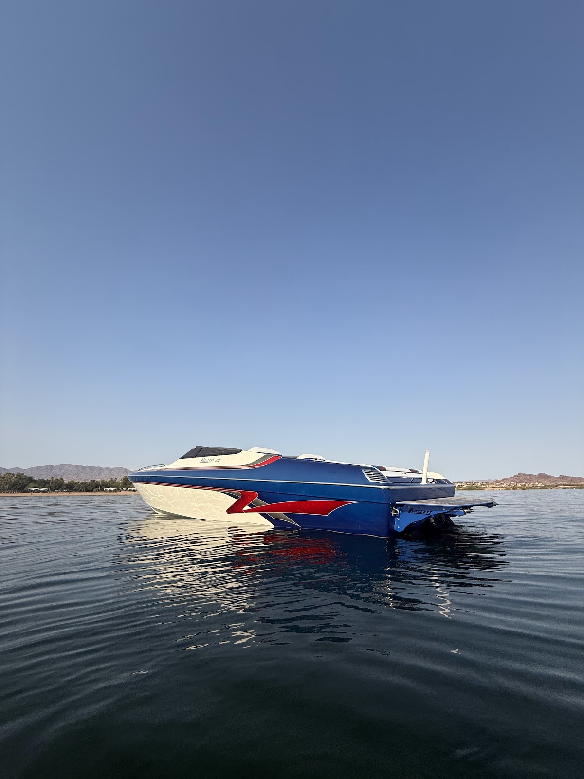 Performance boat floating on calm lake water