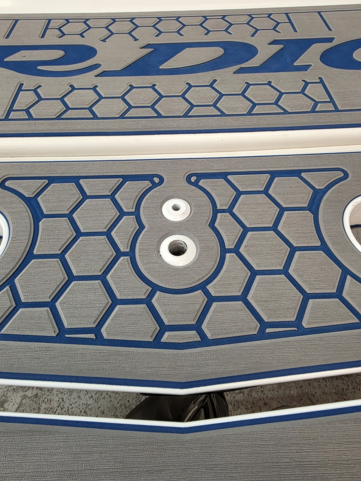 Close-up of blue honeycomb-patterned marine decking with a billiard eight-ball detail