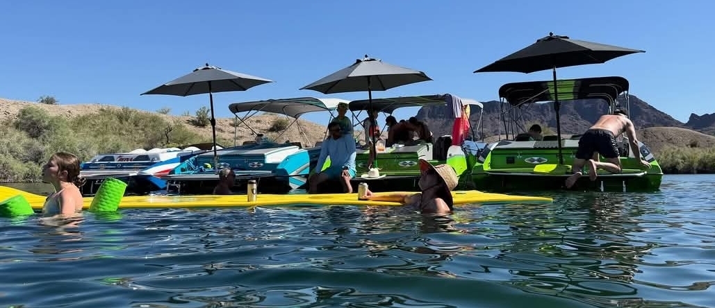 Colorful boats gathered at the sandbar under Sandbar Shade umbrellas