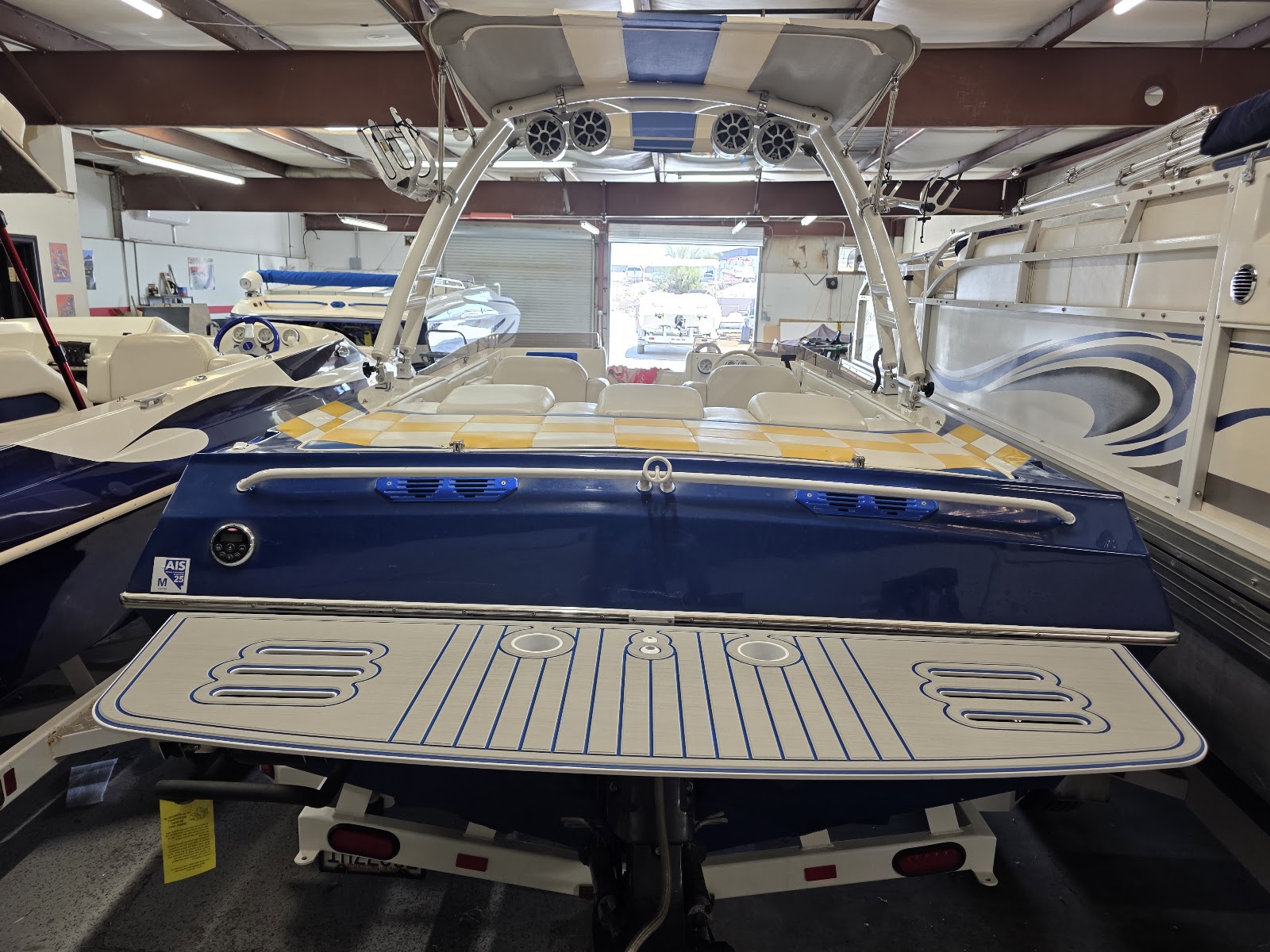 Boat in the shop with a tan-decked custom swim platform