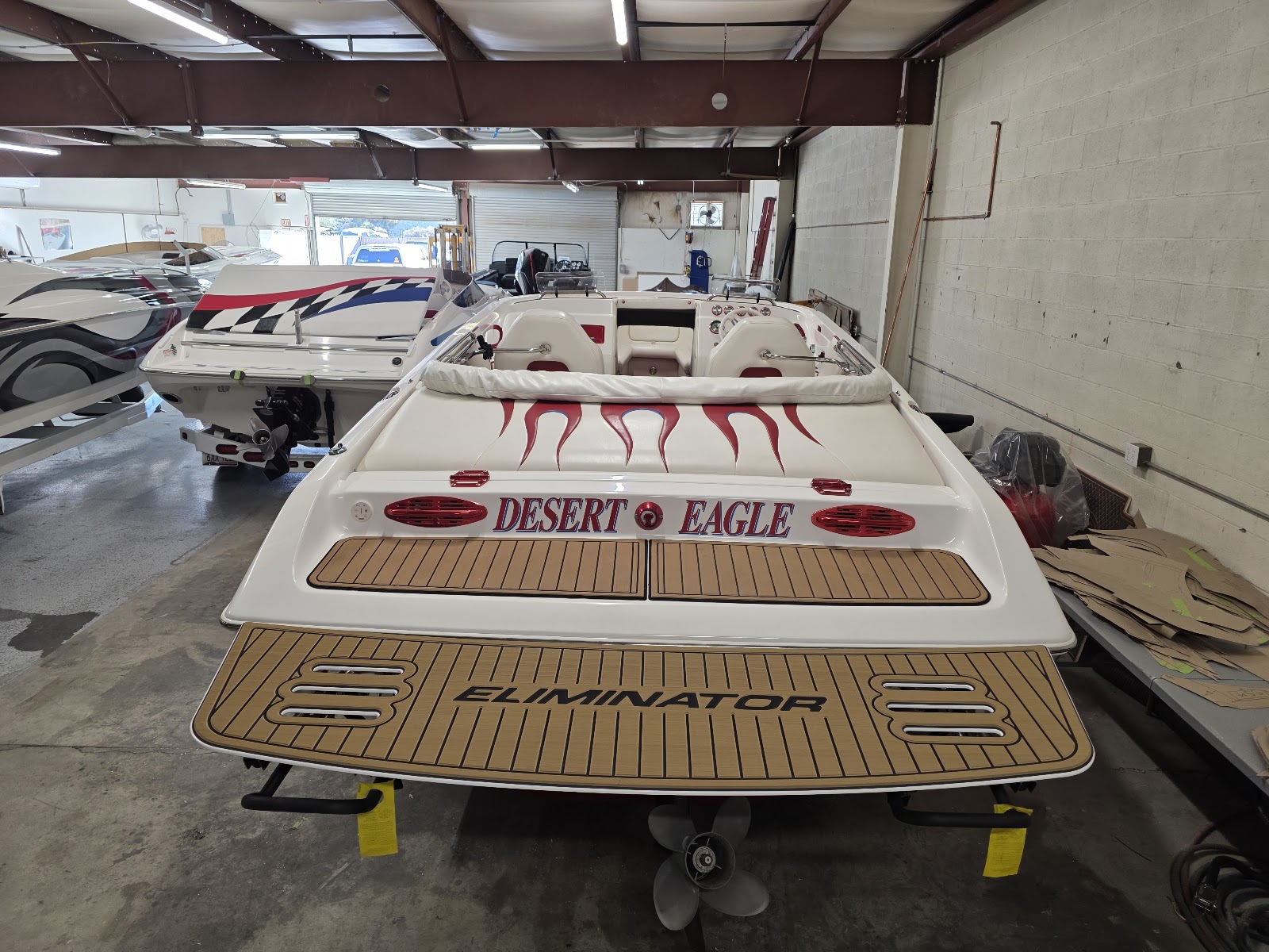 Desert Eagle boat in the shop with a wood-look swim platform