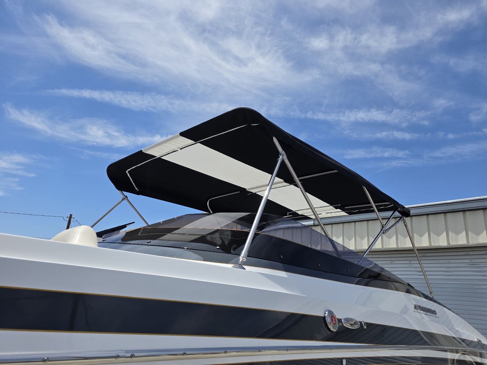 Close view of a black and white bimini top on a white performance boat